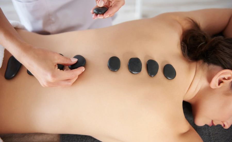 GetWell hot stone therapy being applied to a client’s back during a soothing massage